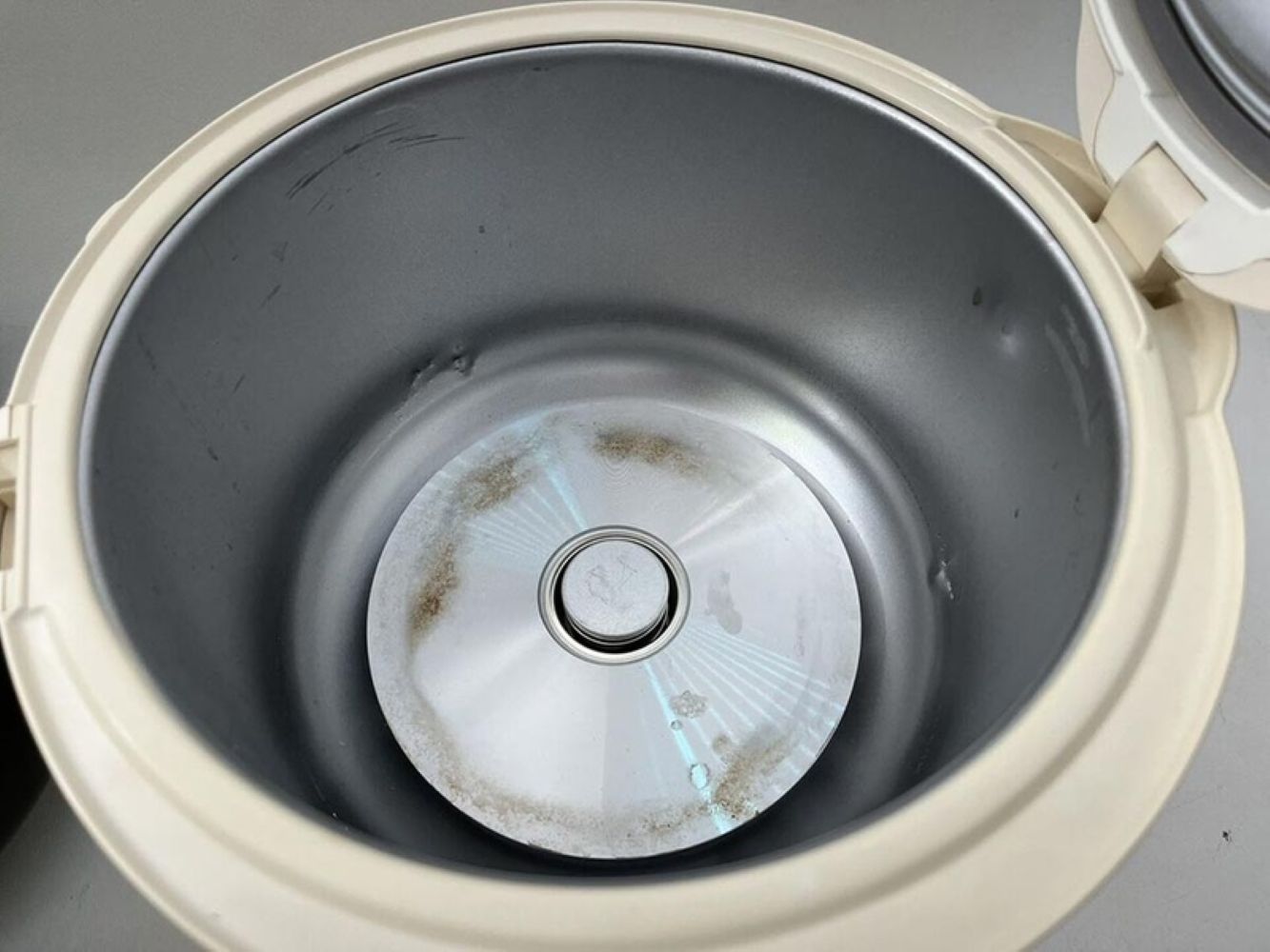 Mâm nhiệt bám cặn hoặc rơ le nhiệt bẩn là lí do nồi cơm không bật được nút (Nguồn: Internet)